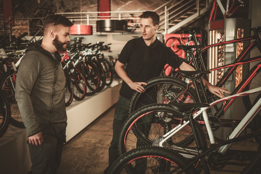 A person buying a bike from a seller in a bike shop